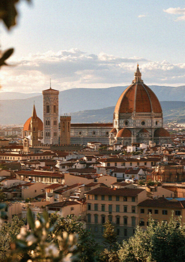 The skyline of Florence with the red dome of the Duomo over terracotta rooftops