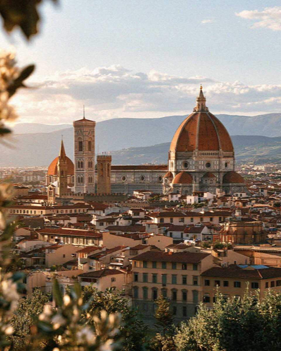The skyline of Florence with the red dome of the Duomo over terracotta rooftops