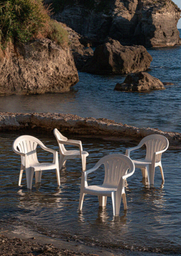 White plastic chairs standing in the shallow thermal water at Sorgeto on Ischia