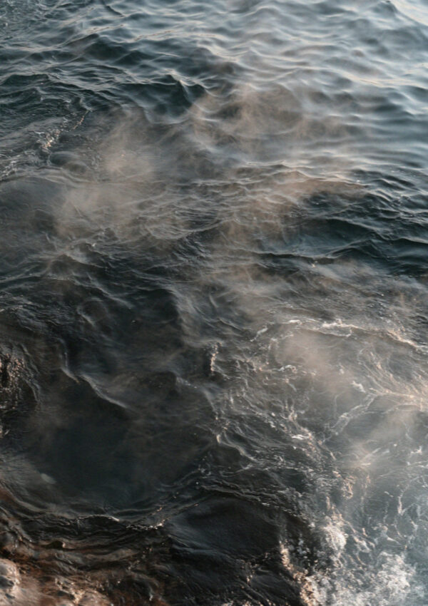 Steam rising off the sea where the hot spring breaks through at Sorgeto on Ischia