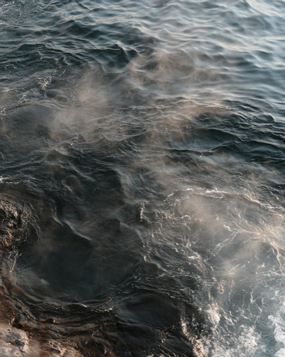Steam rising off the sea where the hot spring breaks through at Sorgeto on Ischia