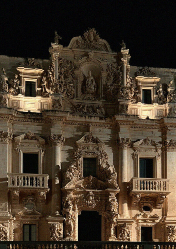 A carved baroque facade in Lecce floodlit at night