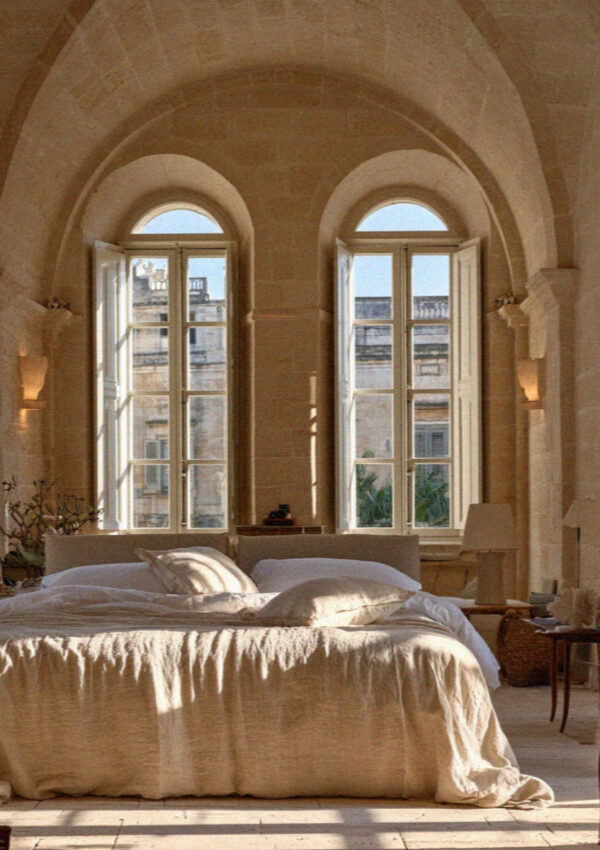 A hotel bedroom under a high vaulted stone ceiling inside an old palazzo in Lecce