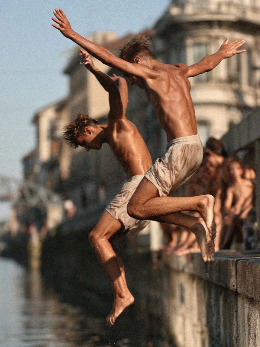 Boys jumping into a Milan canal on a hot evening