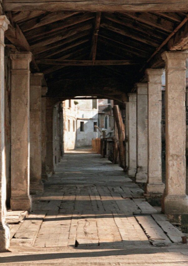A shaded portico passage beside a Milan canal