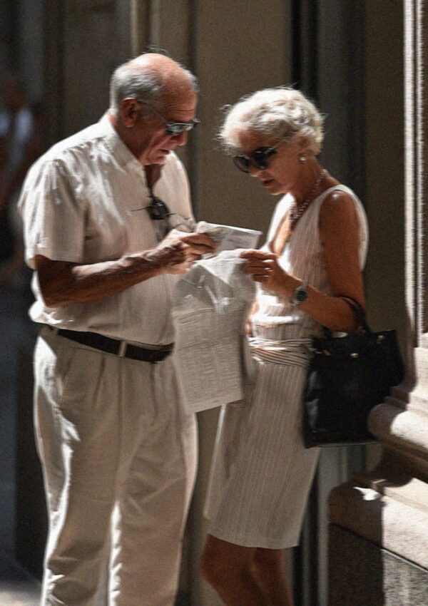 An older couple reading a map in the shade in Milan