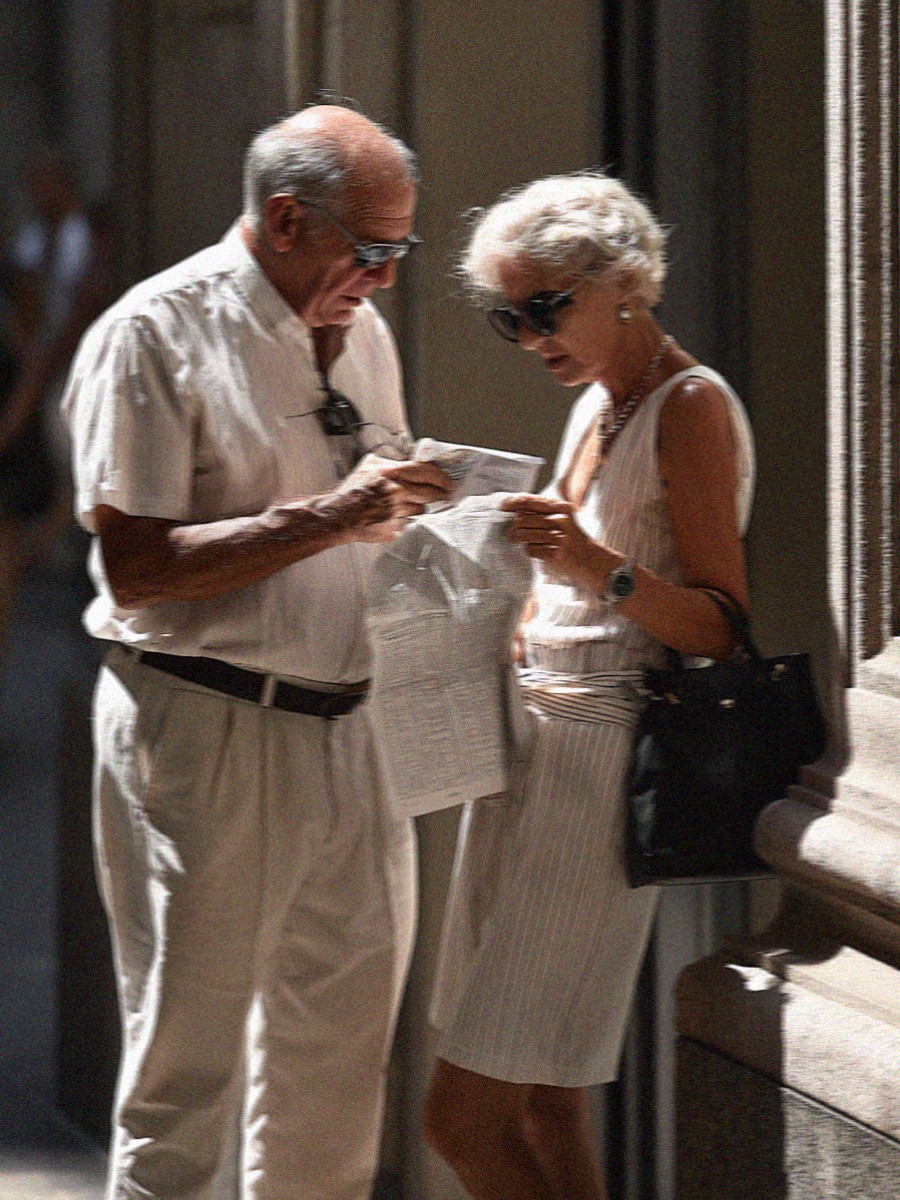 An older couple reading a map in the shade in Milan