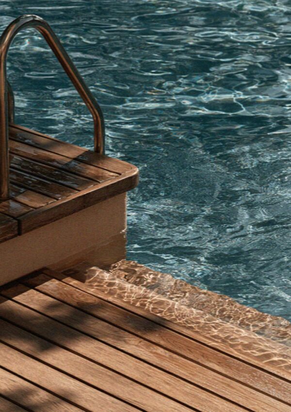 The ladder and wooden deck at the edge of a villa pool outside Milan