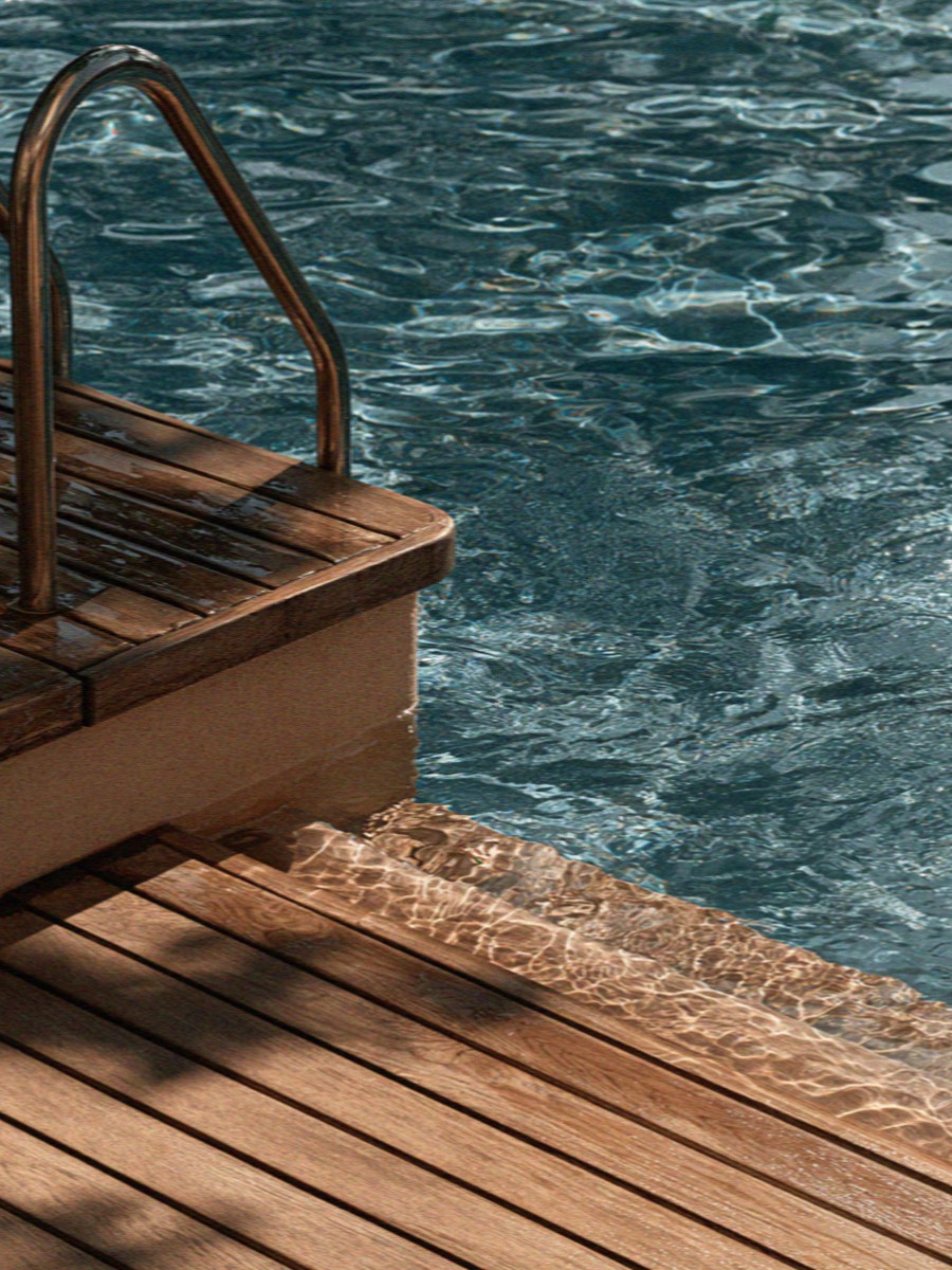 The ladder and wooden deck at the edge of a villa pool outside Milan