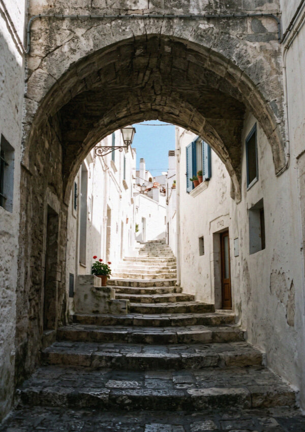 A vaulted stone archway over a narrow lime-washed lane in the old town of Ostuni