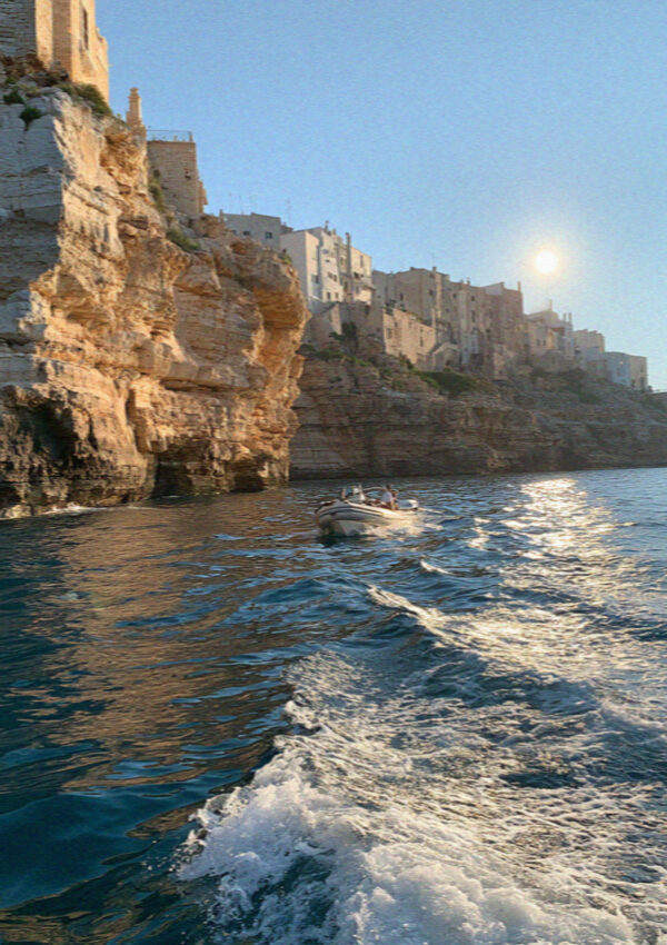 The wake of a small boat below the cliffs of Polignano a Mare