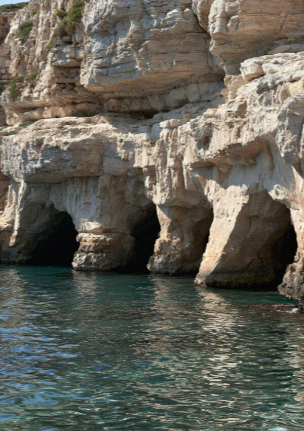 Sea cave mouths in the limestone cliff at Polignano a Mare