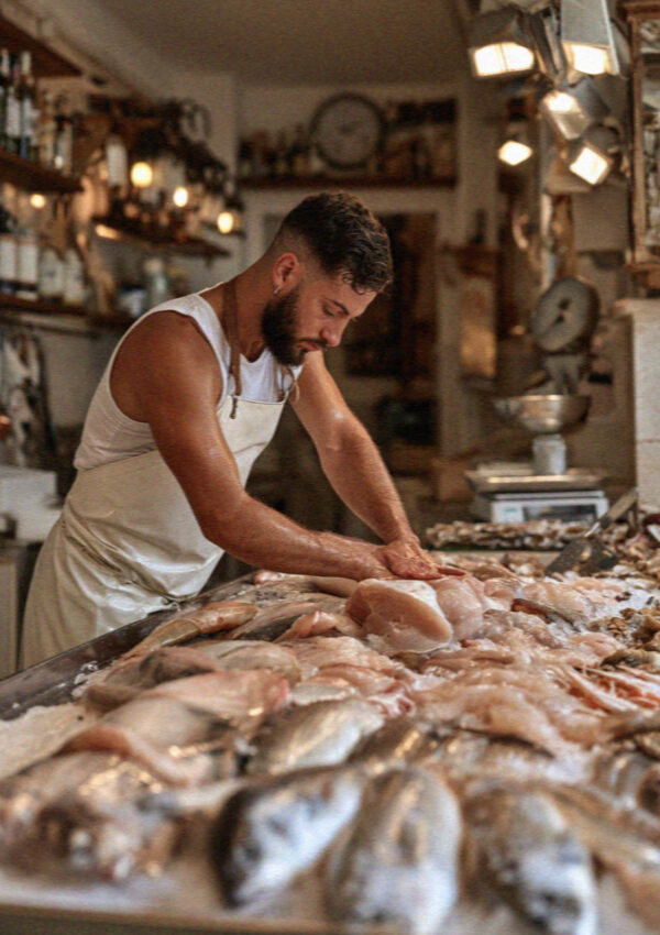 A fishmonger at the counter in Polignano a Mare