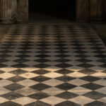A black and white geometric mosaic floor in a house in Pompeii in soft indirect light, no people
