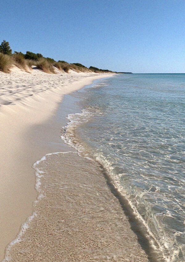 Shallow turquoise water and marram dunes on the Ionian coast of the Salento, near Lecce