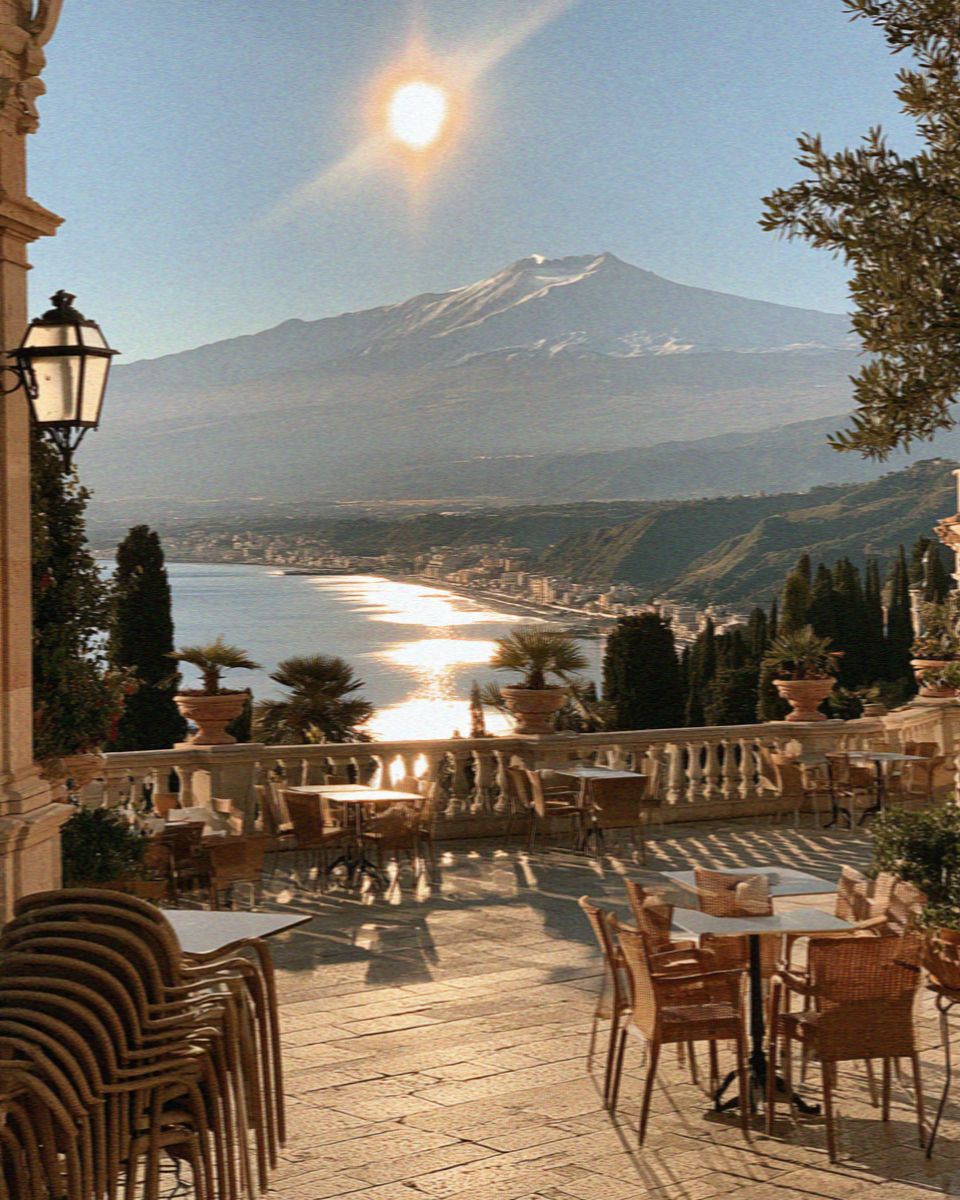 A quiet winter terrace above the sea in Taormina with the snow-capped volcano beyond