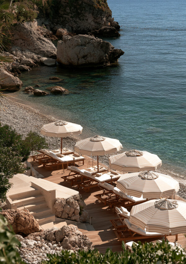 A seafront hotel terrace above the pebble beach below Taormina