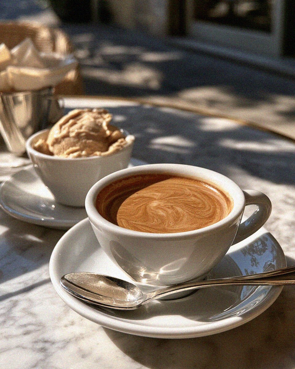 An espresso and a cup of gelato on a marble cafe table in Tuscany
