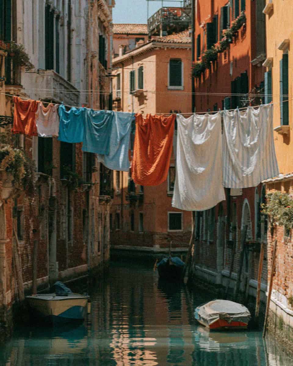 A narrow Venetian canal with washing strung overhead