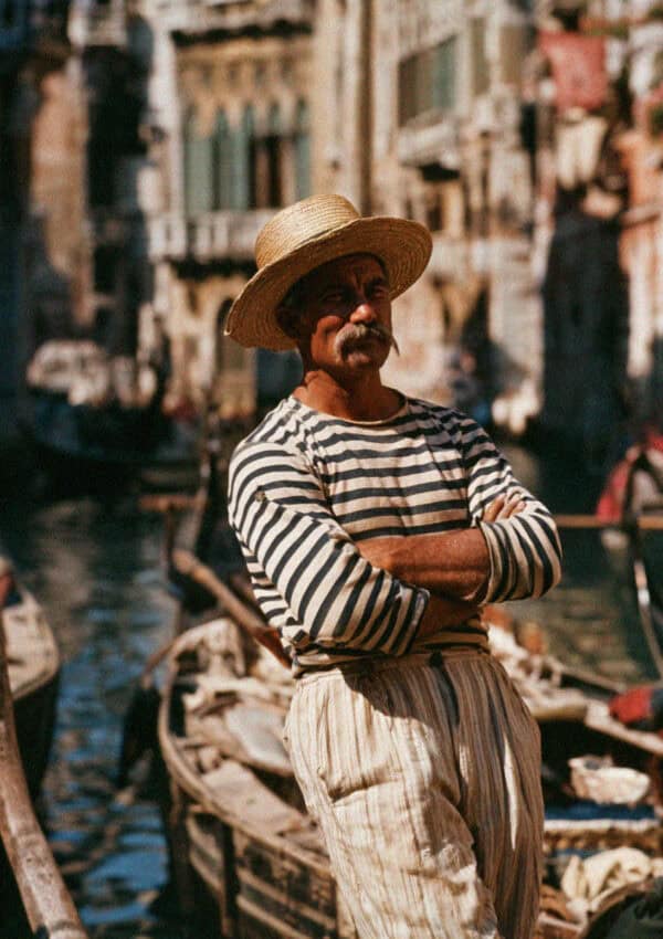A Venetian gondolier resting by his gondola