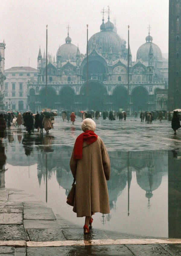 A winter tourist crossing a foggy Piazza San Marco in acqua alta