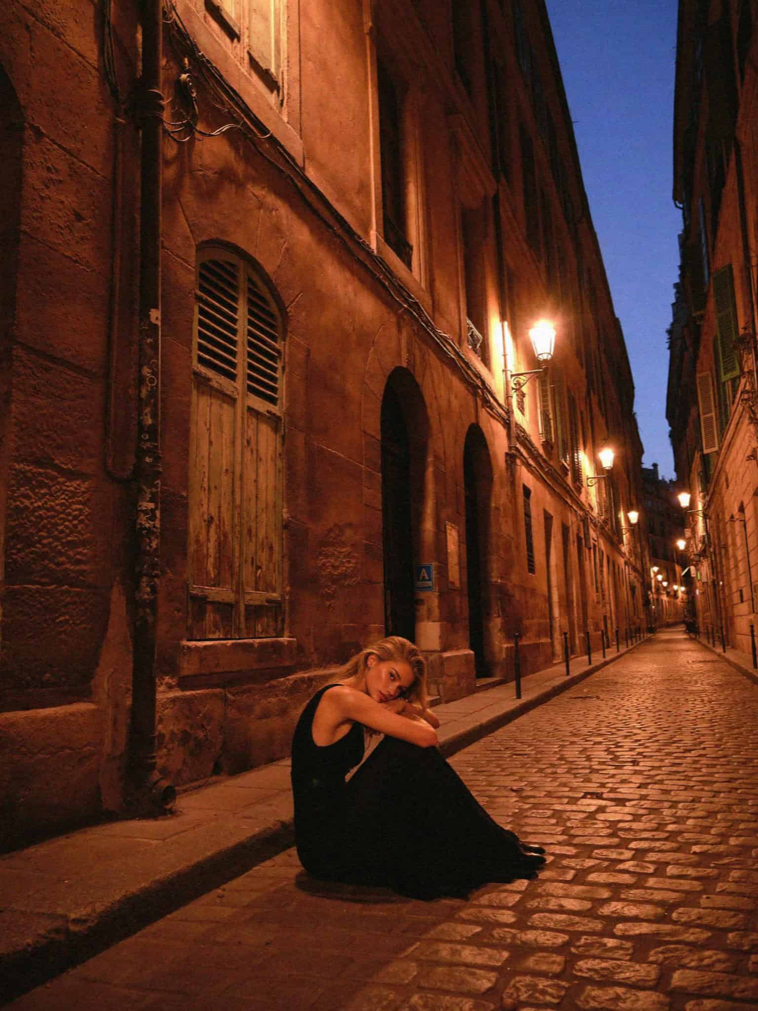 An elegant woman on a lamplit Verona lane at night