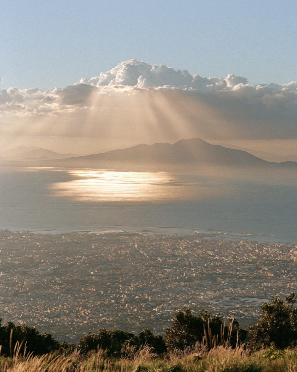 The whole Bay of Naples seen hazy from high on the slope of Vesuvius, the city and the sea below, no people