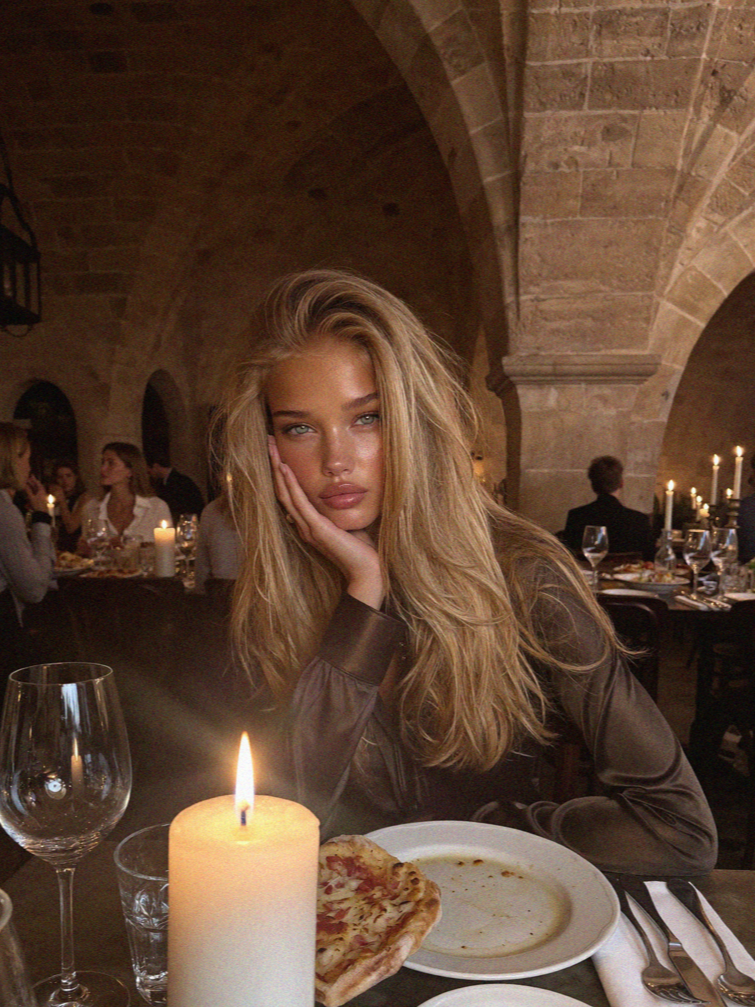 Victoria van der Berg at a candlelit table in a stone-vaulted Assisi trattoria