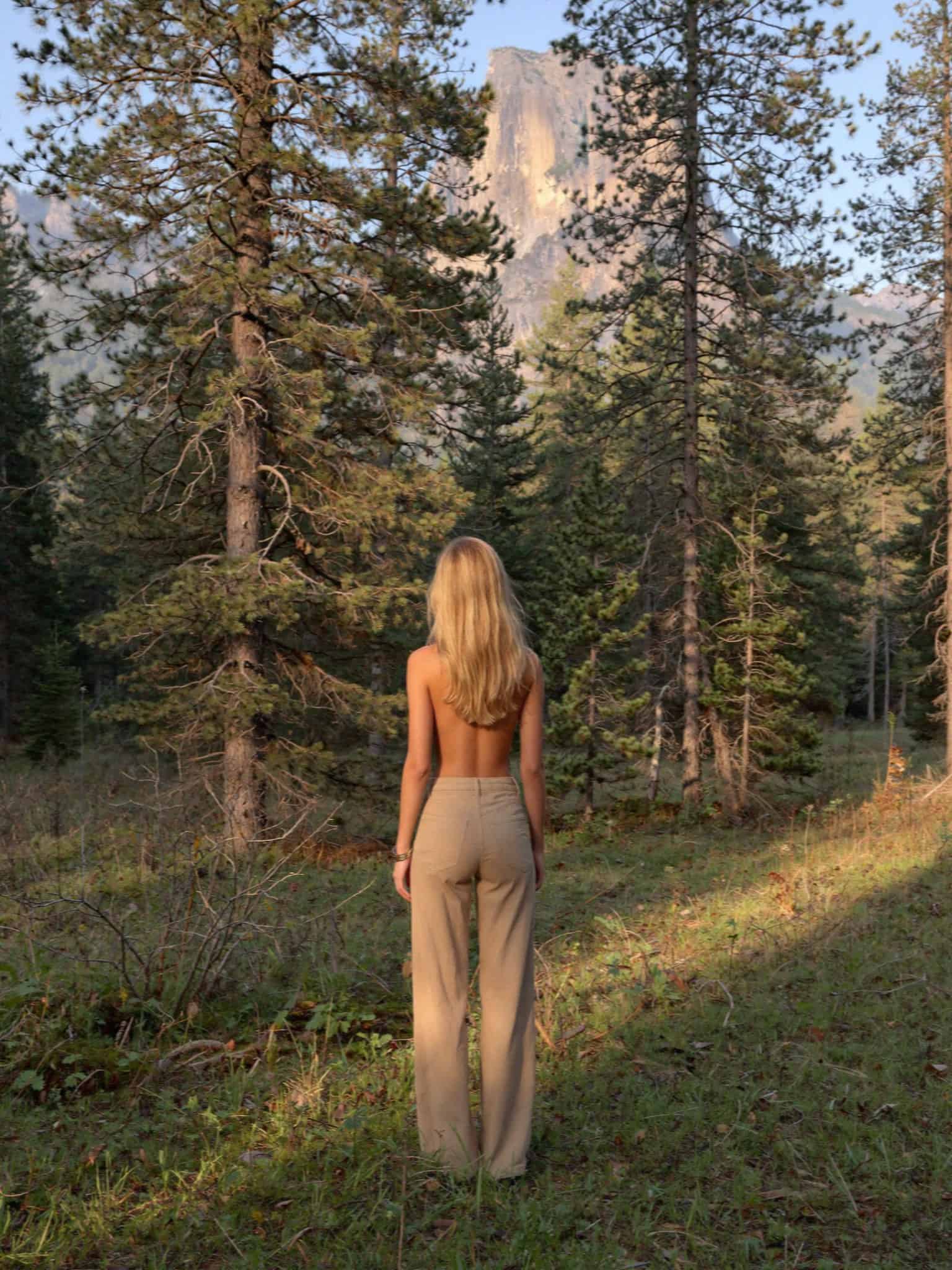 Victoria Van Der Berg walking among the larches at dusk in the Dolomites