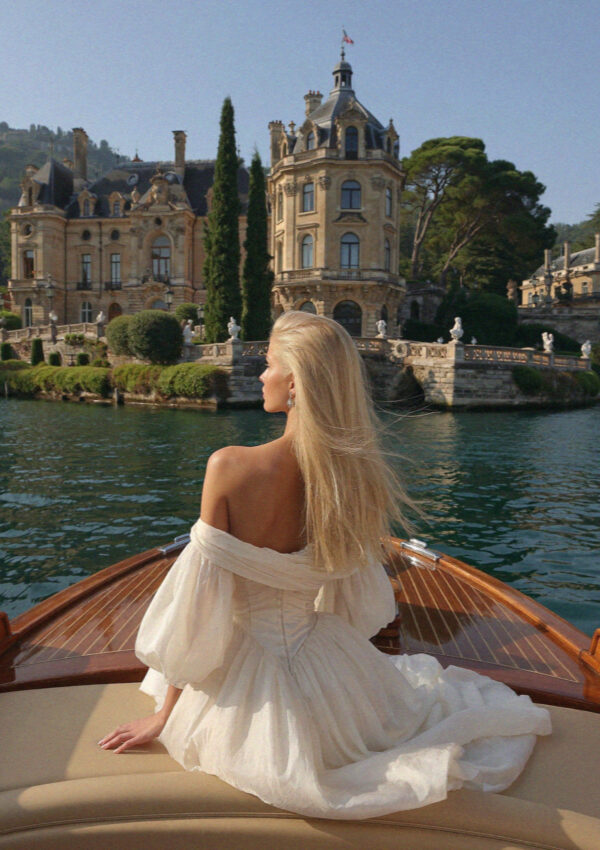 Victoria van der Berg in a wedding gown arriving by classic wooden Riva boat with a Lake Como villa behind