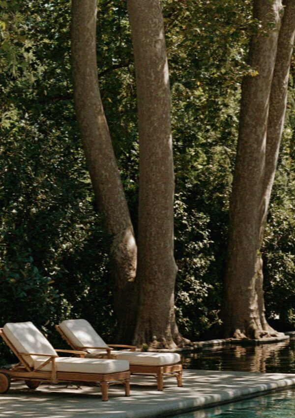 Loungers under the trees beside the villa pool outside Milan