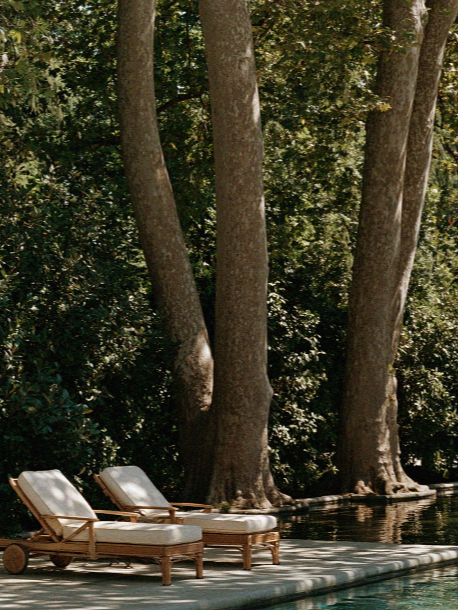 Loungers under the trees beside the villa pool outside Milan