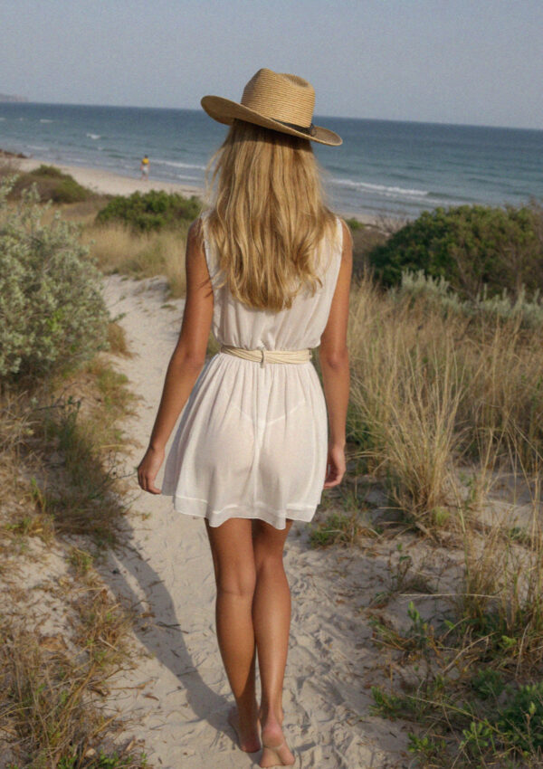 Victoria van der Berg walking a sand path through dunes to the beach near Ostuni