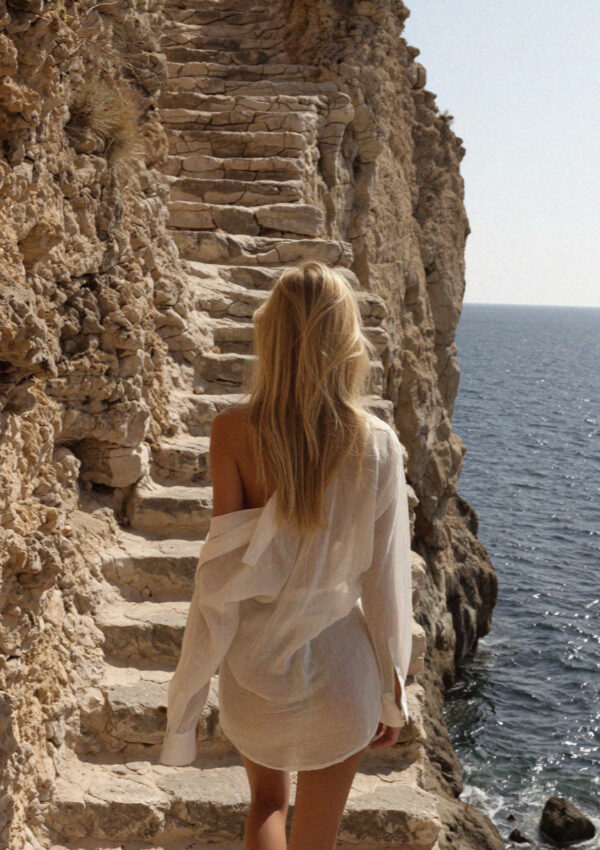 Victoria van der Berg on the stone stairs down to Lama Monachile in Polignano a Mare