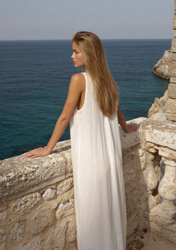 Victoria van der Berg on the warm limestone wall above the cove in Polignano a Mare