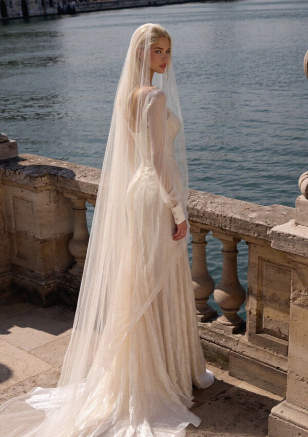 Victoria van der Berg in an ivory silk wedding gown with a long veil on a tiered stone loggia above Lake Como