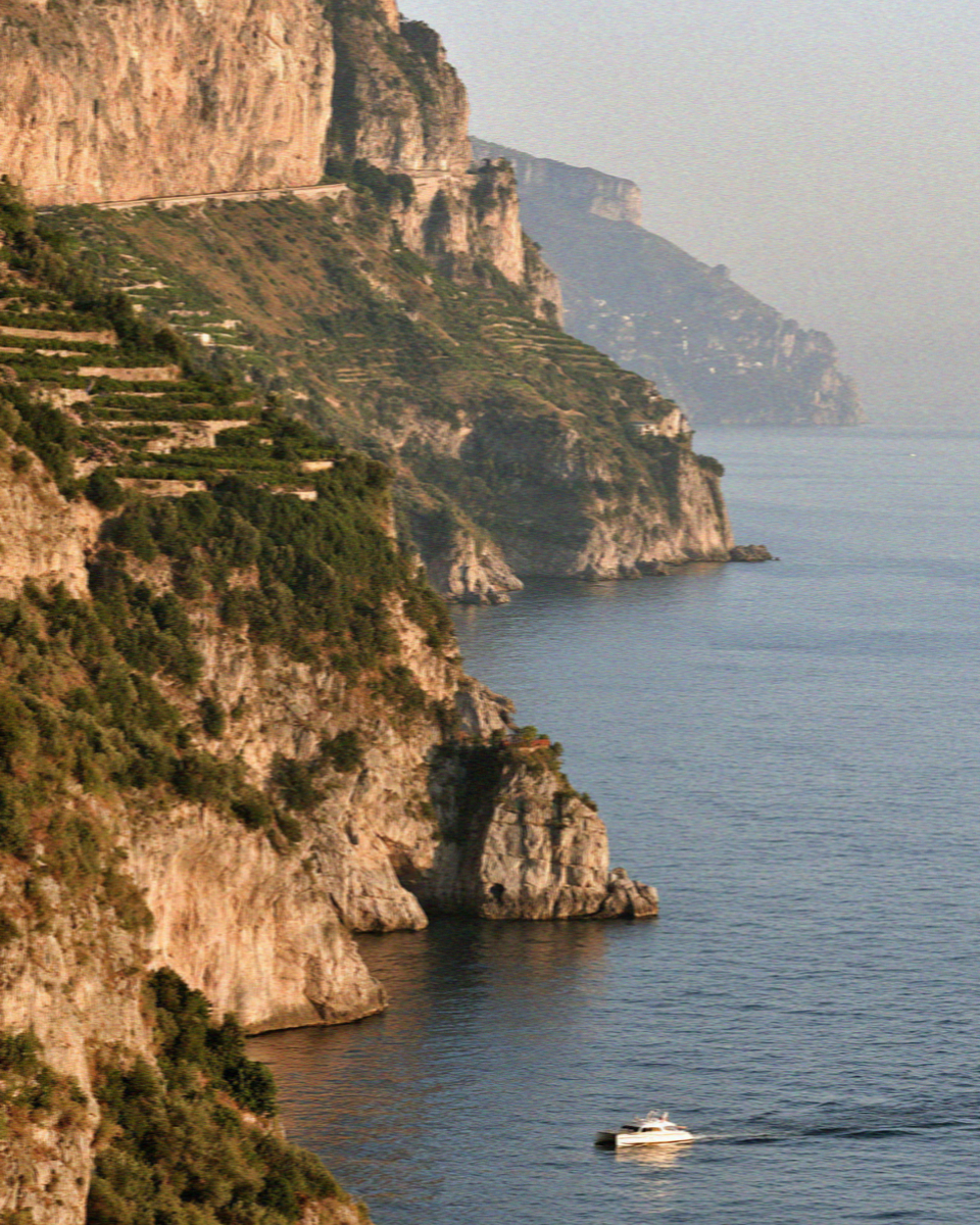 A small boat below the cliffs of the Amalfi Coast in early morning