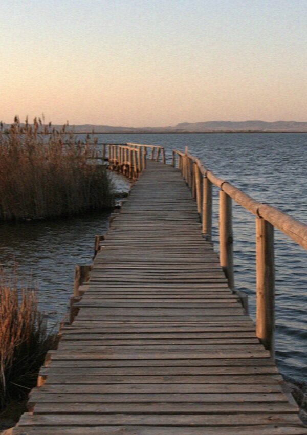 A wooden boardwalk running out over the shallow salt pans in Cagliari in Sardinia