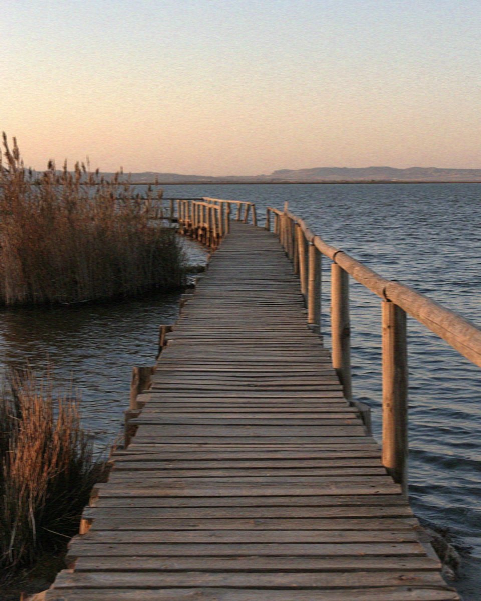 A wooden boardwalk running out over the shallow salt pans in Cagliari in Sardinia