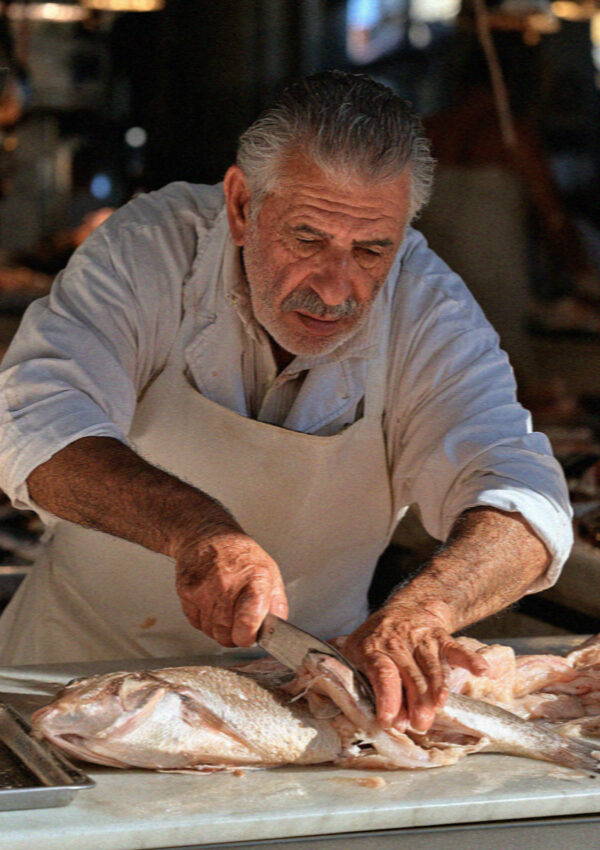 A fishmonger at work in the covered market in Cagliari, Sardinia