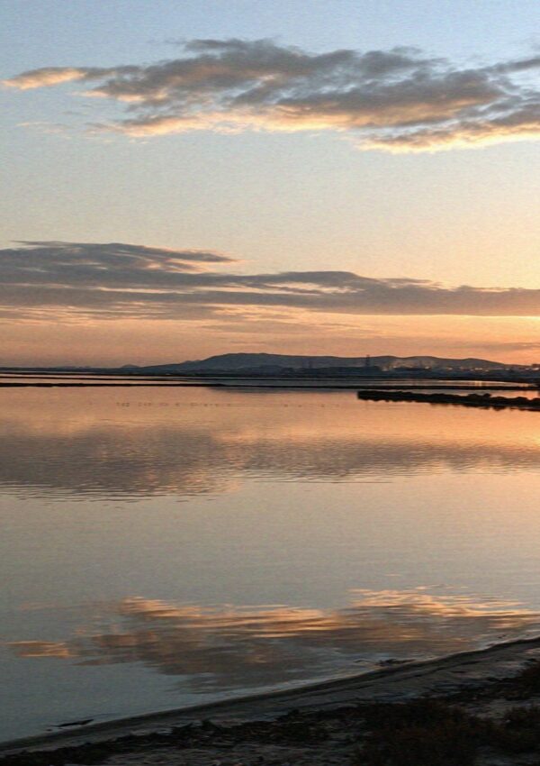 The old salt pans lying flat as a mirror at dusk in Cagliari in Sardinia