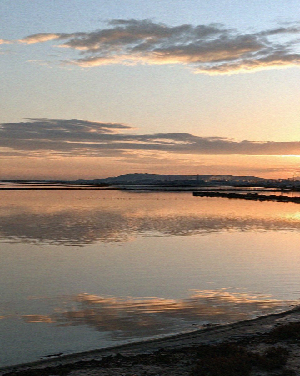 The old salt pans lying flat as a mirror at dusk in Cagliari in Sardinia