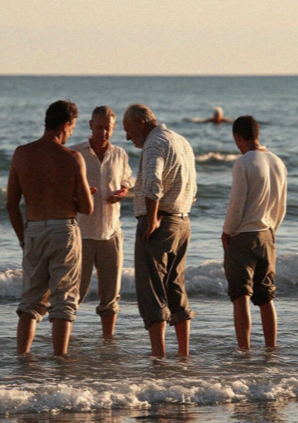 Men still in work shirts with their trousers rolled at Poetto beach in Cagliari