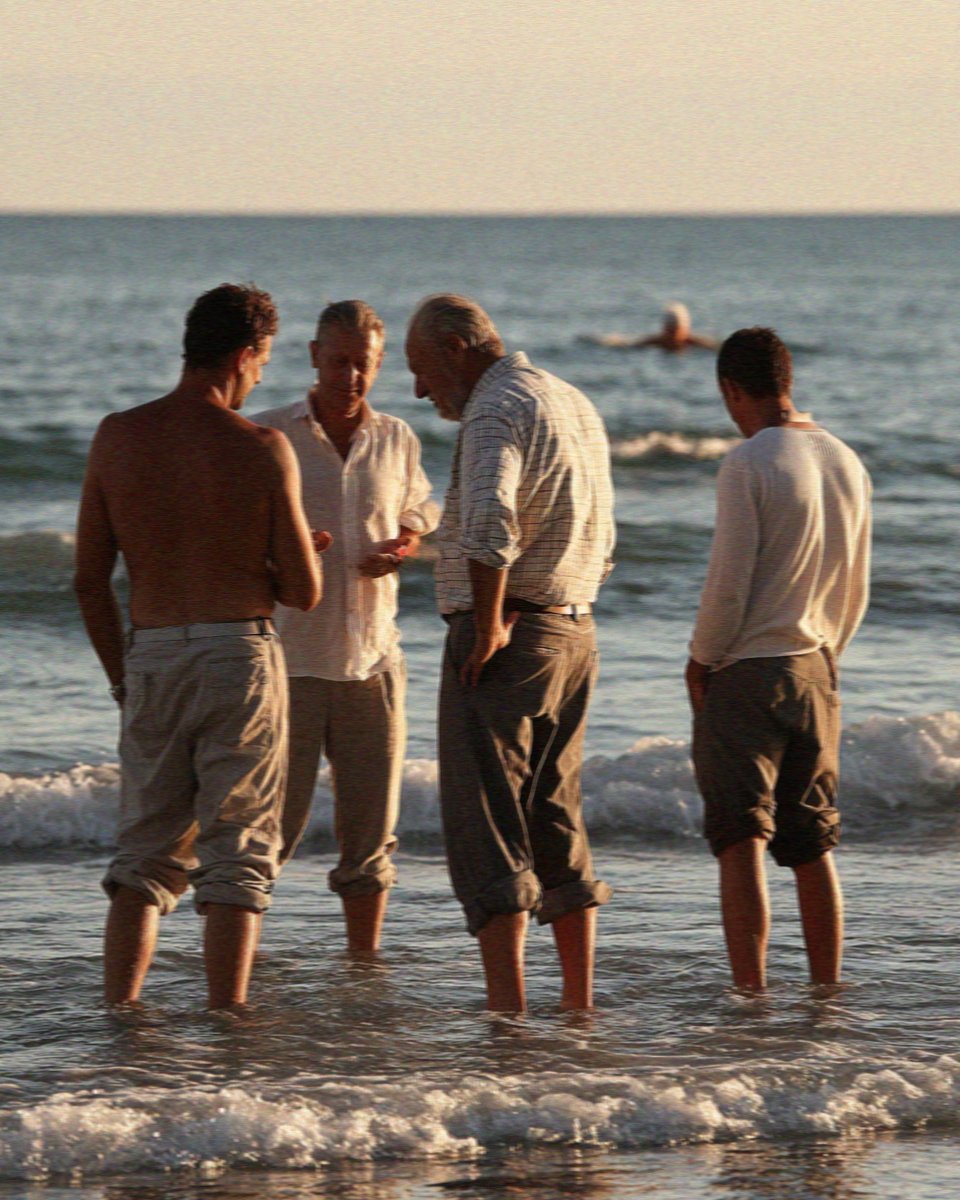 Men still in work shirts with their trousers rolled at Poetto beach in Cagliari