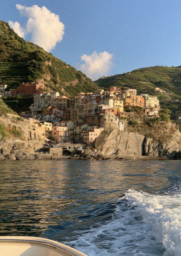 A Cinque Terre village seen from a boat offshore in the late afternoon