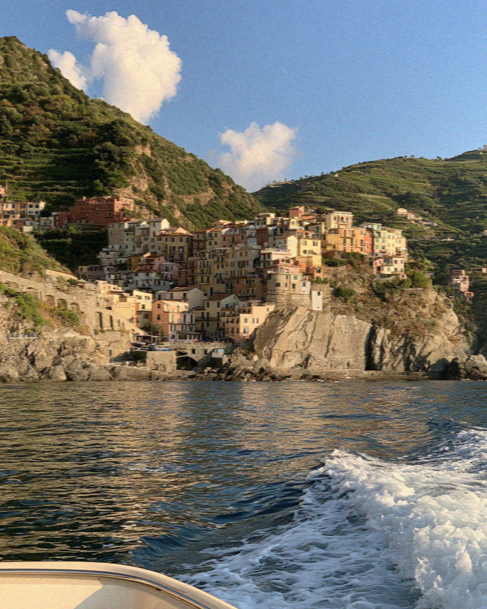 A Cinque Terre village seen from a boat offshore in the late afternoon