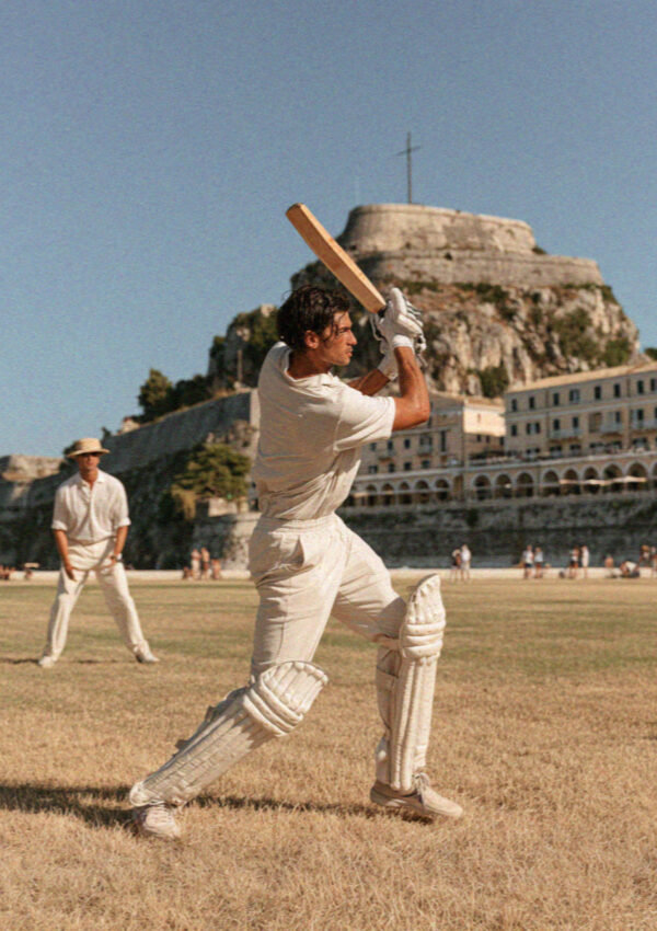 A batsman playing a shot on the cricket green below the old fortress in Corfu Town