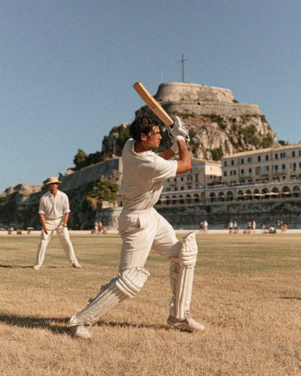 A batsman playing a shot on the cricket green below the old fortress in Corfu Town