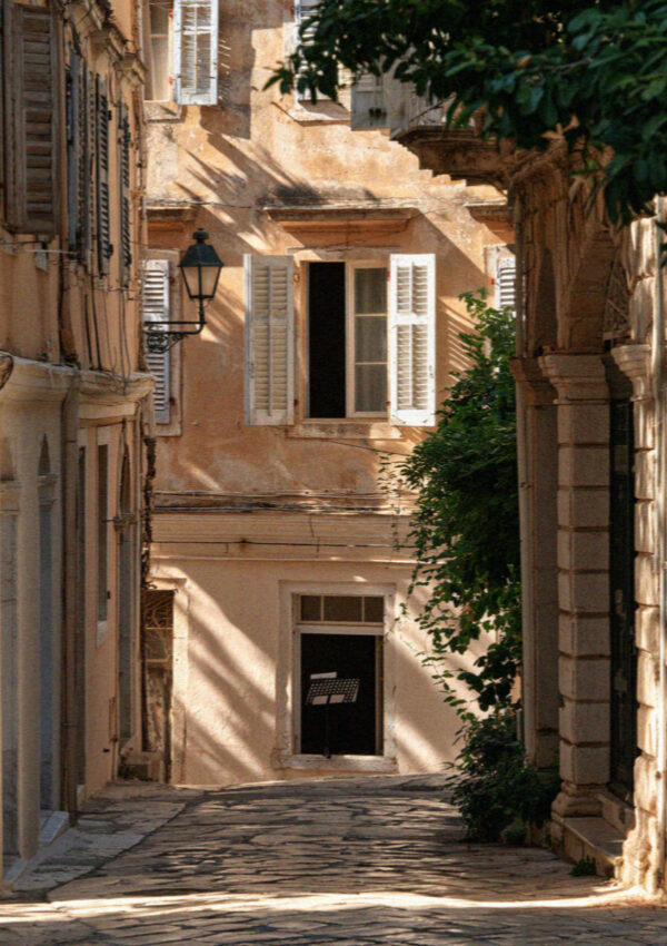 A narrow Venetian lane in ochre and faded pink in Corfu Town in the Ionian islands