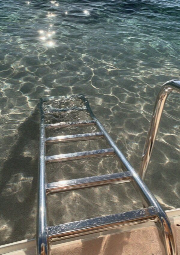A boat ladder going down into clear water in the archipelago north of the Costa Smeralda in Sardinia